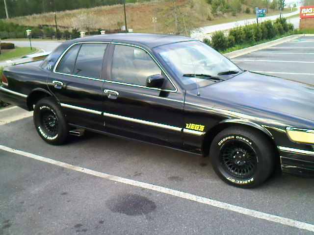 Black full-size sedan with black steel wheels, Cooper Cobra tires and JEGS decal