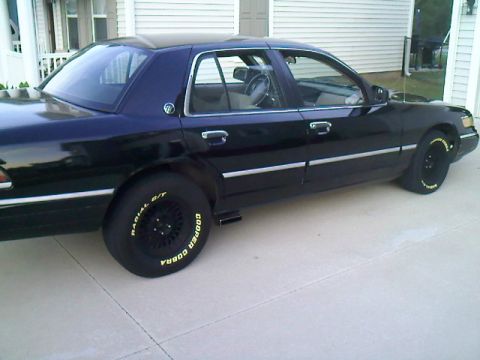 1993 Mercury Grand Marquis - A dark 1993 Mercury Grand Marquis sedan is parked on a concrete driveway.