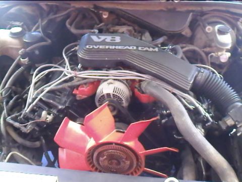 1993 Mercury Grand Marquis - Close-up view of a V8 engine bay, highlighting the valve cover and cooling fan.