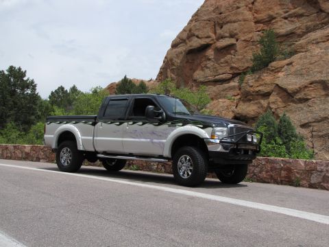 1995 Ford Bronco - This pickup truck features a custom flame graphic on its side and a brush guard on the front.