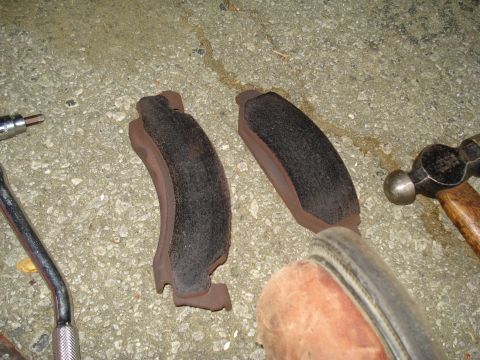 1984 Ford Bronco - New brake pads are laid out next to tools on the ground, ready for installation.