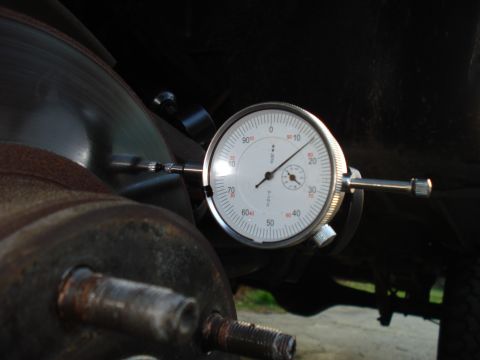 1984 Ford Bronco - A dial indicator is used to measure the brake rotor's runout on a rusty hub.