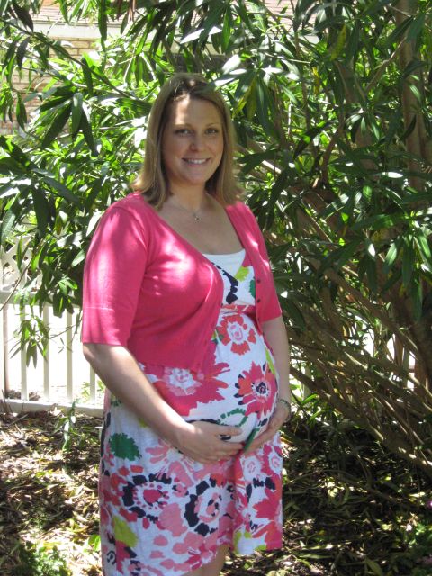 2008 Ford F-250 - A pregnant woman smiles while holding her belly in front of a leafy green background.