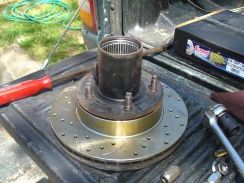 1984 Ford Bronco - Brake rotor and hub assembly with tools and parts on a truck bed.
