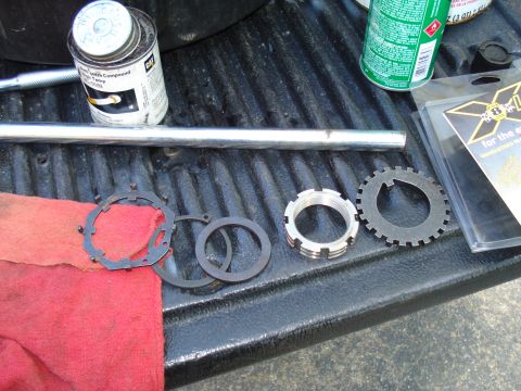 1984 Ford Bronco - Various metal brake components and tools are laid out on a textured surface, possibly a truck bed.