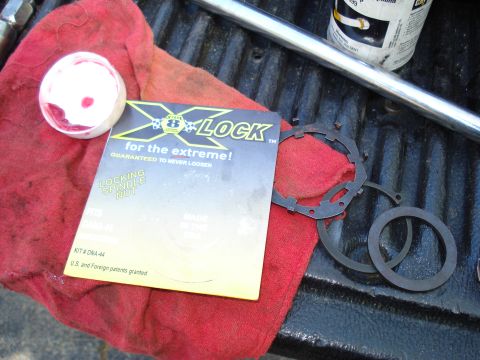 1984 Ford Bronco - X-LOCK locking spindle nut kit and associated parts laid out on a red cloth, likely for a vehicle repair or upgrade.