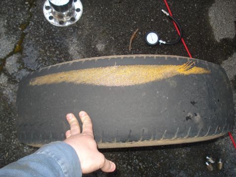 1994 Ford F-350 - A hand reaches towards a dark-colored engine part with a yellow stripe visible.