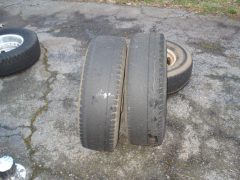1994 Ford F-350 - Close-up of two used tires resting on cracked pavement with a third tire visible.