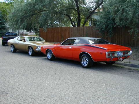 1979 Ford Bronco - Three vehicles parked on a street: an orange 1971 Dodge Charger, a gold 1974 Plymouth Satellite, and a black pickup truck.