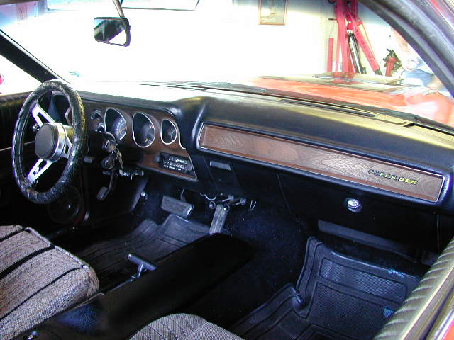 Interior view of a 1973 Dodge Charger SE showing dashboard, steering wheel, and seats. Woodgrain trim on dash reads 'CHARGER SE'