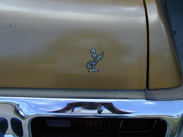 Gold vehicle with roadrunner emblem on rear quarter panel