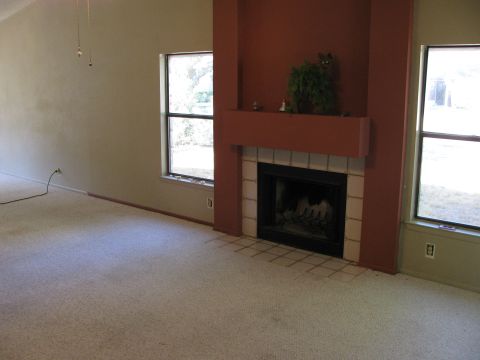 1983 Ford 427 - Interior scene a fireplace with a terracotta surround and two windows overlooking an outdoor area.