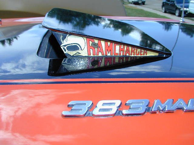 Orange car hood with black hood scoop reading "RAMCHARGER" and a skull graphic, "383 MAG" badging below