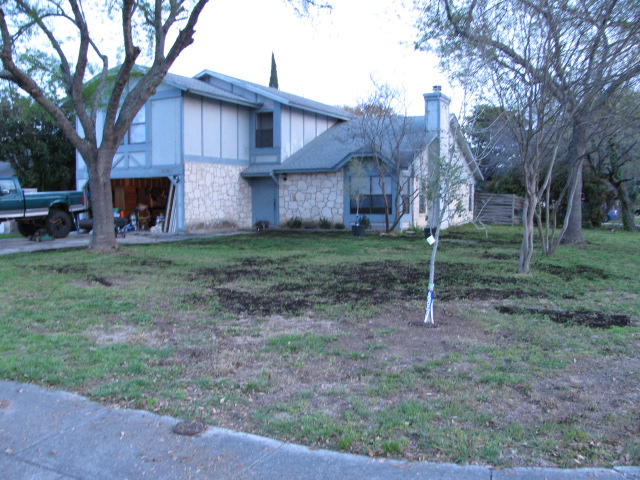 House with a green pickup truck parked in the driveway next to the garage