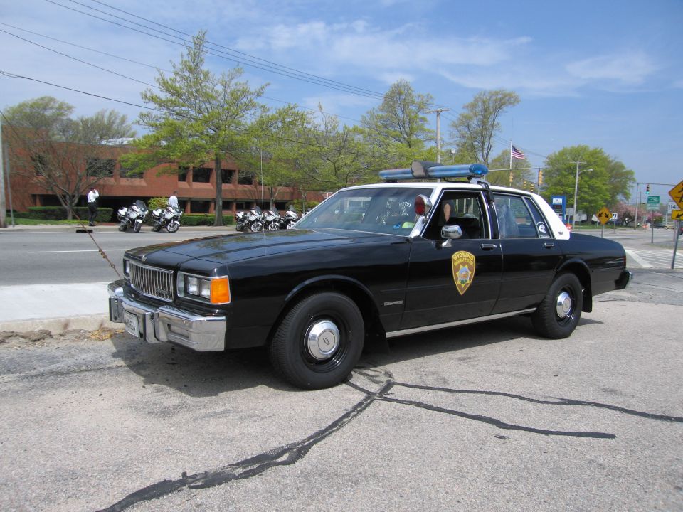 Black-and-white Chevrolet Caprice police sedan parked near motorcycles