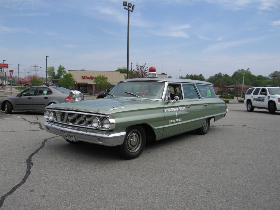 Green vintage Stratford Police station wagon with roof beacon
