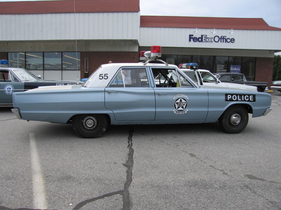 Light blue vintage Police sedan number 55, side view with roof lights