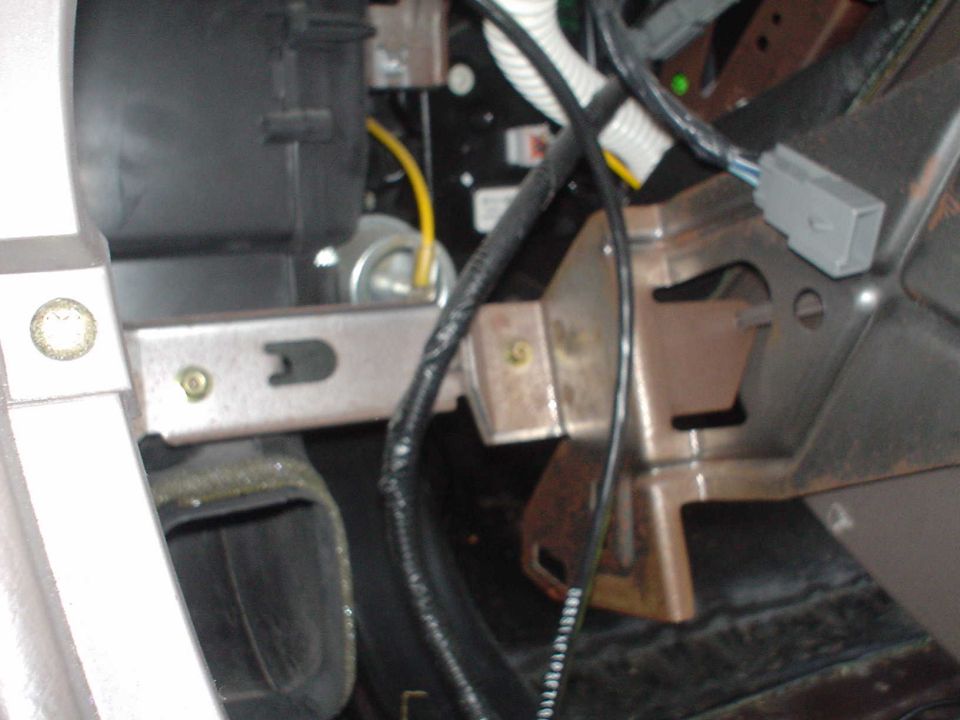 This is a picture of the stuff behind the shifter. This shot was taken from rightwhere the floor shifter knob would be facing forward. The open air duct you see is the one for the passenger vents in the back.