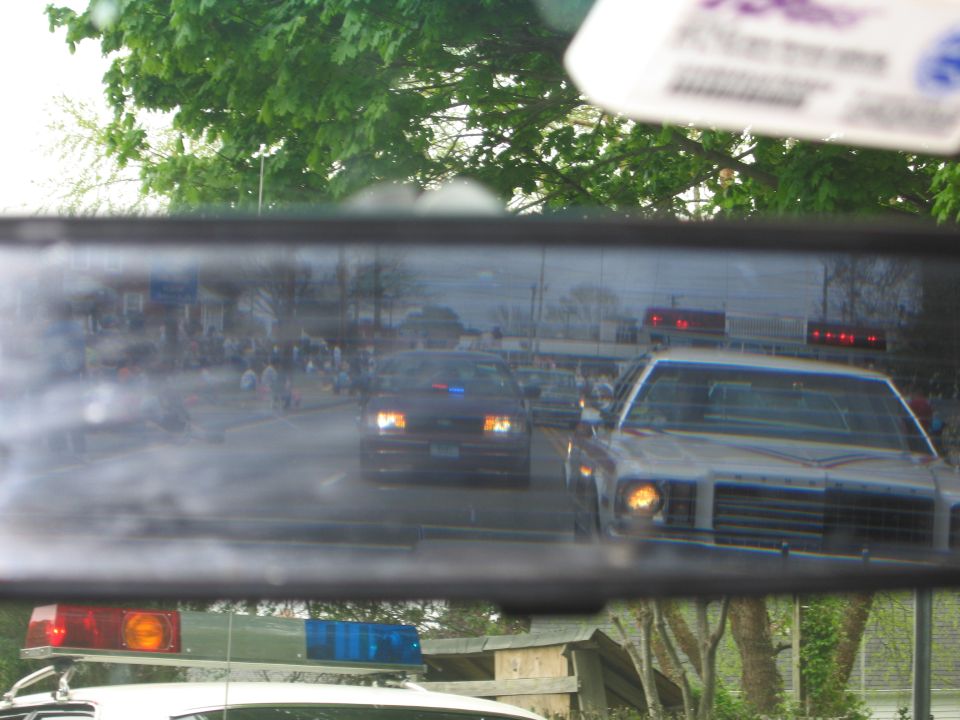 Rearview mirror reflection of police cars on a street