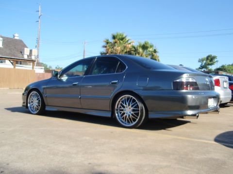 2003 Acura TL - A dark gray 2003 Acura TL is parked in a lot on a sunny day, showing off its custom wheels and tinted windows.
