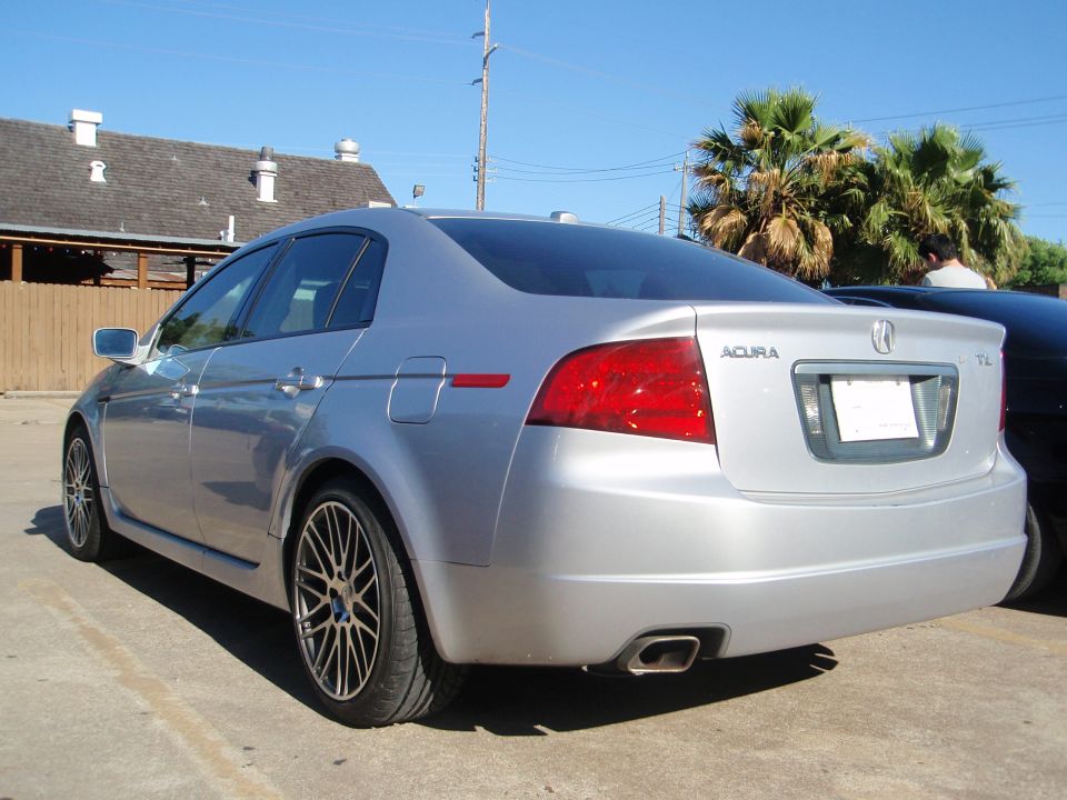 Silver 2003 Acura TL rear quarter view. Features distinctive taillights and alloy wheels