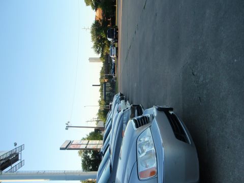 2003 Acura TL - A row of cars are parked on a lot under a clear sky, with a sign visible on the closest vehicle.