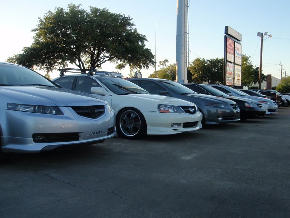 Front view of a silver 2003 Acura TL, with other Acuras lined up behind it