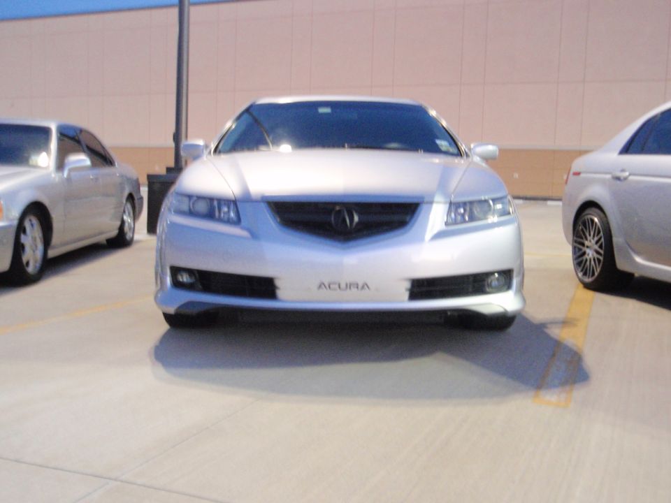 Silver Acura sedan front view with grille and headlights visible