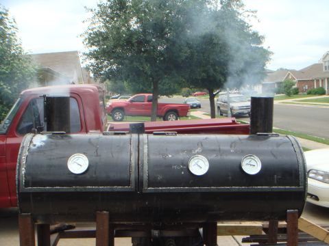 1992 Ford Bronco - A finished shop-built black barrel smoker with two hinged lids, three round Tel-Tru temperature gauges and twin square stacks venting smoke…