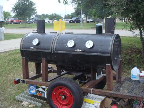 1992 Ford Bronco - Homebuilt black barbecue smoker made from a steel pipe with three dial thermometers, twin chimney stacks and a yellow warmer box, mounted o…