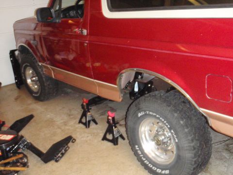 1995 Ford Bronco - Rear view of a red 1995 Ford Bronco being worked on, supported by jack stands.