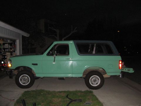 1996 Ford Bronco - A green 1996 Ford Bronco is seen parked in a driveway at night.