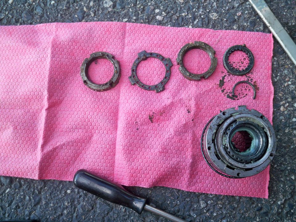 Disassembled locking hub parts and snap rings laid out on a pink shop towel