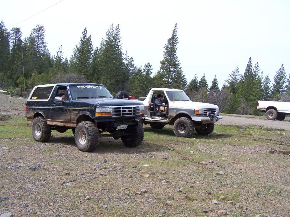 Dark blue Ford Bronco with lifted suspension and large tires, seen from a 3/4 front angle