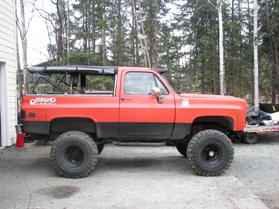 Orange and black lifted SUV with offroad decal on side, side view