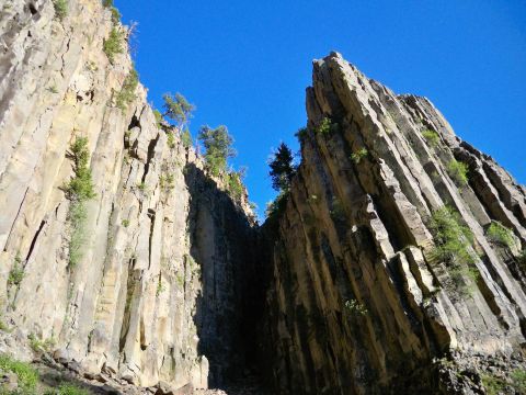 1994 Ford Bronco - The photo shows a natural landscape of towering rock columns against a bright blue sky, with some greenery clinging to the sides.