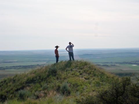 1994 Ford Bronco - Two individuals pause on a hilltop, taking in the expansive view of the rolling green terrain.