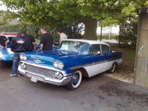 1991 Ford Crown Victoria - A classic blue and white two-tone sedan, likely a 1958 model, is displayed at an outdoor car show.