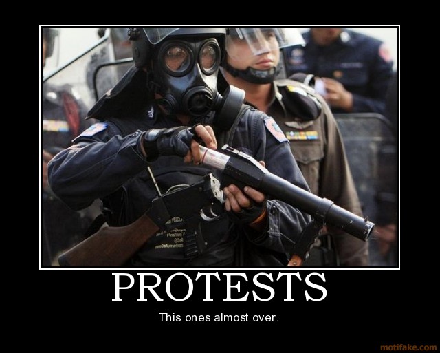 Riot police officer in gas mask holding a weapon
