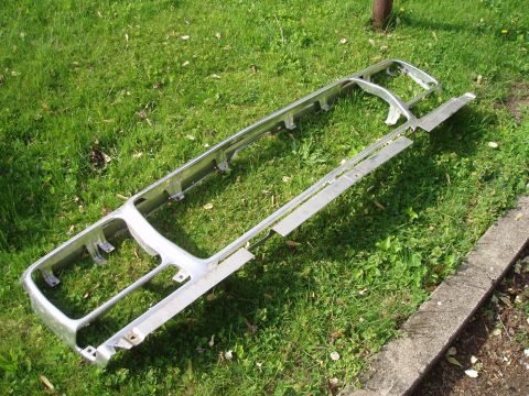1979 Ford Bronco - A chrome grille assembly is shown outdoors on a grassy area next to a concrete curb.