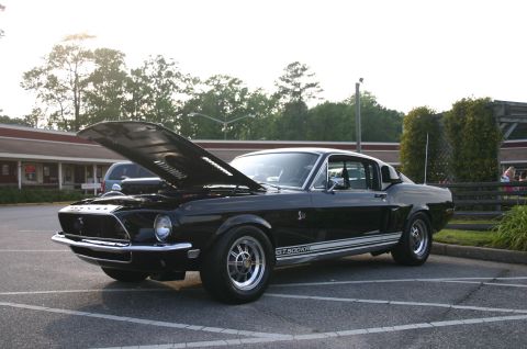 1968 Shelby GT500 - A black 1968 Shelby GT500KR is parked with its hood up, showing off its engine bay.