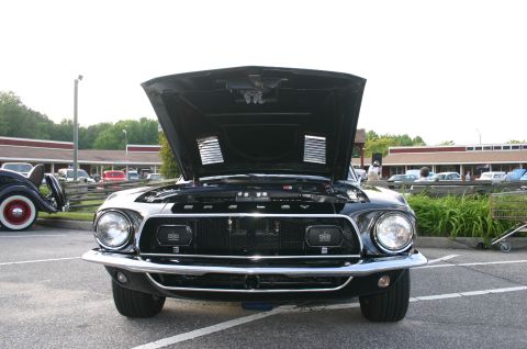 1968 Shelby GT500 - Front view of a black 1968 Shelby GT500 with its hood open, parked in a lot with other vehicles.