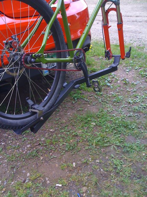 2010 Hyundai Genesis - A bicycle is attached to a rack on the back of a red car.