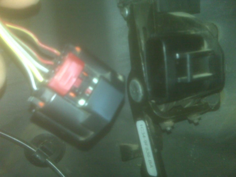 Close-up of a vehicle electrical connector with wires and a black component