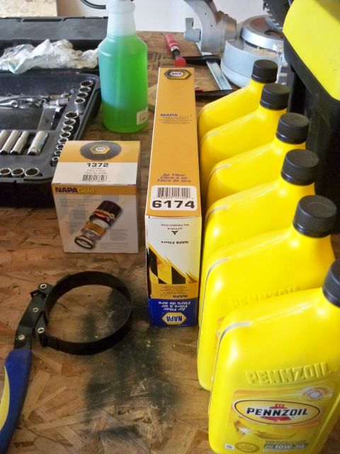 1994 Ford Bronco - Collection of automotive maintenance supplies including filters, oil, and a filter wrench.