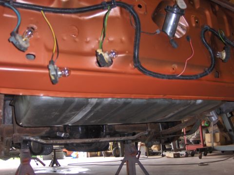 1980 Chevrolet Camaro - Car's underbody with fuel tank and electrical wiring visible, supported by jack stands.