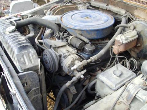 1976 Ford F-150 - The engine bay of a vehicle, showing the radiator, air cleaner, and various engine components.