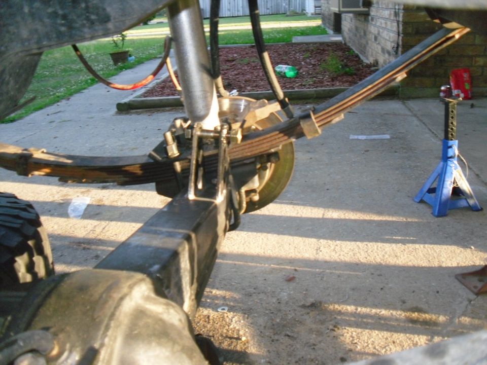 Rear axle and leaf spring suspension with shock absorber