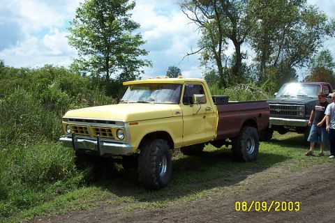 1996 Ford Bronco - Modified 1975 Ford F-Series pickup truck parked outdoors with another vehicle and people nearby.