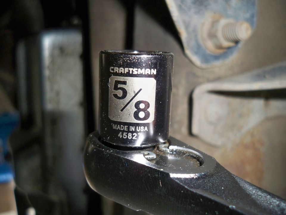 Craftsman 5/8 inch socket on a ratchet wrench, with vehicle components in the background